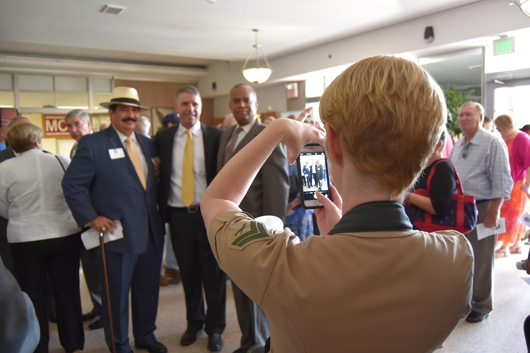 Cpl. Diana Sims, a combat camera photographer, snaps a photo for some veterans.