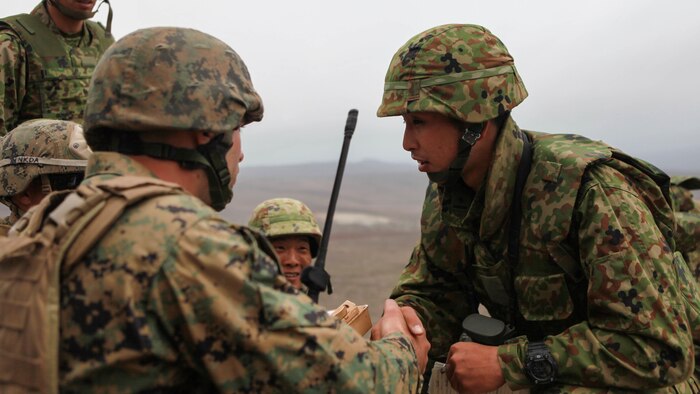 A Marine with 3rd Air Naval Gunfire Liaison Company and a Japanese soldier shake hands prior to the start of a live-fire shoot together during Exercise Dawn Blitz 2015 at San Clemente Island, California, Sept. 1, 2015. ANGLICO Marines and Japanese soldiers conducted a combined arms shoot with naval gunfire, attack rotary aircraft and 120mm mortars. Dawn Blitz is a multinational training exercise designed to enhance Expeditionary Strike Group Three and 1st Marine Expeditionary Brigade’s ability to conduct sea-basing operations, amphibious landings, and command and control capabilities alongside Japan, Mexico and New Zealand.