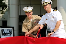 NAVAL STATION GREAT LAKES -- Marine Col. Jason Morris, 9th Marine Corps District commanding officer, and Navy Capt. James D. Hawkins, Naval Station Great Lakes commanding officer, cut the ribbon to officially open the 9th Marine Corps District headquarters building during a ribbon cutting ceremony aboard the Naval Station, Sept. 1, 2015. The ceremony also commemorated the 78th anniversary of the unit's activation as 9th Reserve District, which was established aboard the Naval Station, Sept. 1, 1937. Col. Jason Morris, the District's commanding officer, spoke during the ceremony about the importance of recruiting and how maintaining a well-qualified, well-trained Marine Corps begins with the individual recruiter on the streets. The District is responsible for recruiting enlisted, officer and prior service Marines across 660,000 square miles and 13 states in the Midwest region. 