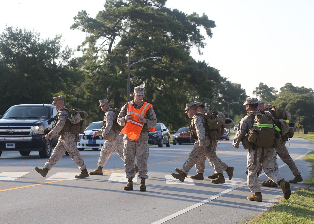 U.S. Marines and U.S. Navy Sailors with the 22nd Marine Expeditionary Unit (MEU) command element cross the street during a 5-mile conditioning hike at Marine Corps Base Camp Lejeune, N.C., Aug. 21, 2015. The hike gave the MEU command element an opportunity to build comradery and prepare for future hikes of greater distance and heavier loads. (U.S. Marine Corps photo by Gunnery Sgt. Matt Epright/Released)