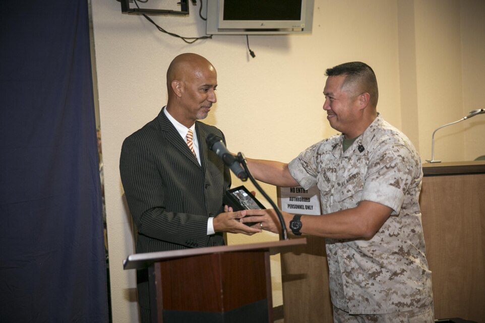 Ramon L. Vargas-Ortiz, administration specialist, G-1 Adjutant’s Office, receives an award for his work towards the Combined Federal Campaign presented by Combat Center Sergeant Major, Sgt. Maj. Karl Villalino, during the CFC kickoff lunch, Sept. 1, 2015. (Official Marine Corps photo by Pfc. Levi Schultz/Released)
