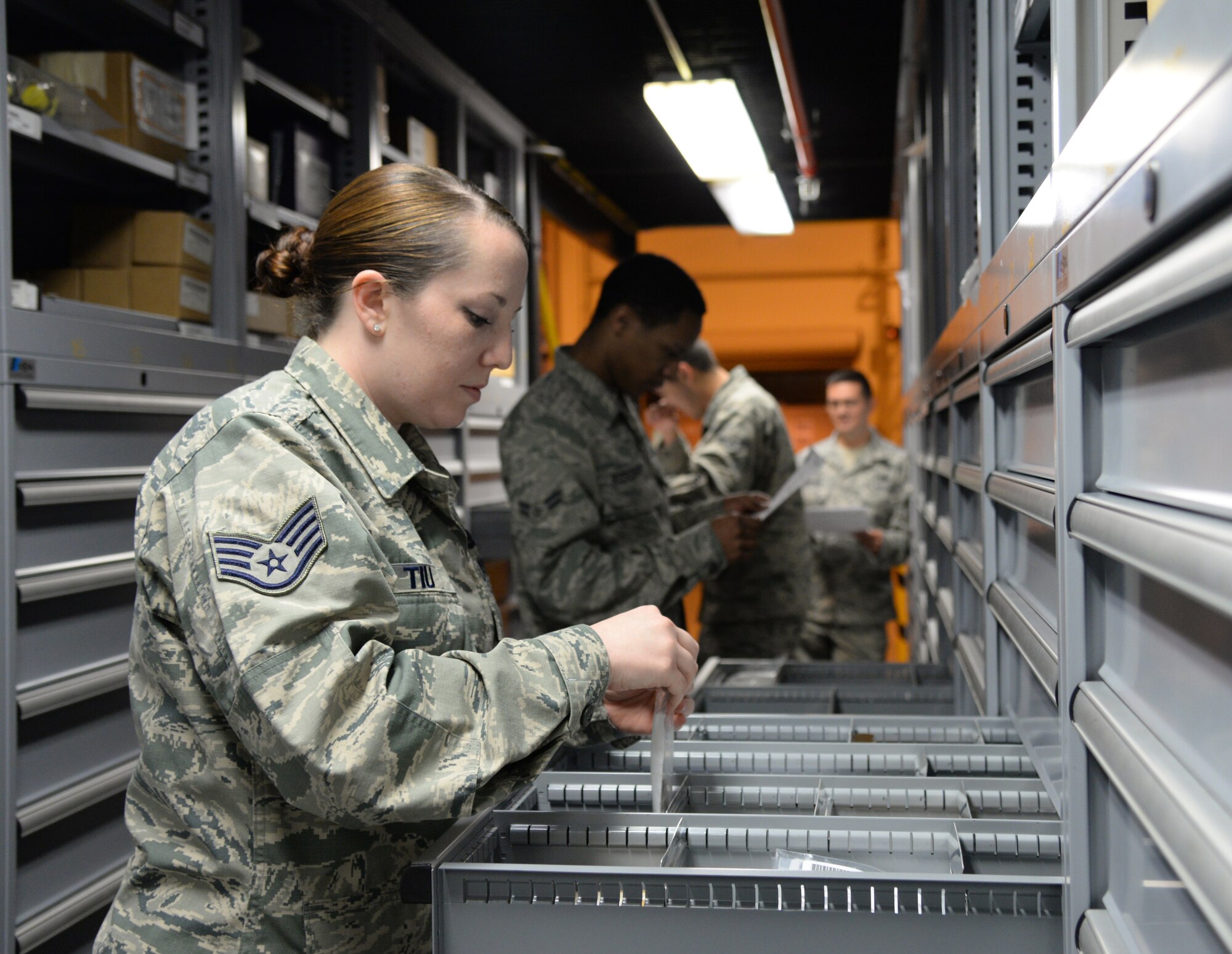 U.S. Air Force Staff Sgt. Rachel Tiu, the 354th Logistics Readiness Squadron NCO in-charge of inventory, goes through inventory with other Airmen, Sept. 1, 2015, at Eielson Air Force Base, Alaska. Tiu and other Airmen put away inventory items in the bins when they are all accounted for. (U.S. Air Force photo by Airman 1st Class Cassandra Whitman/Released)