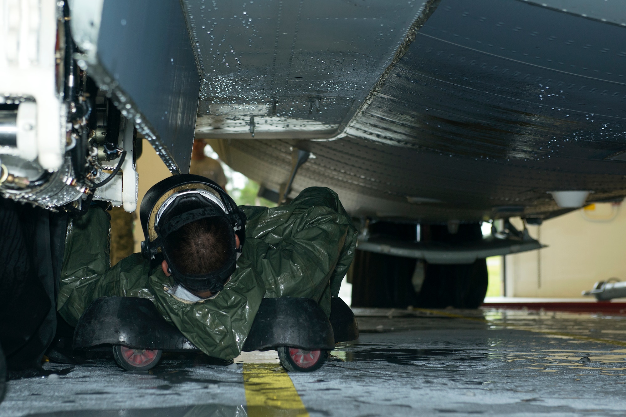 U.S. Air Force Airman 1st Class Alex Trillana, 71st Rescue Squadron crew chief, cleans the friction washer under an HC-130J Combat King II Sept. 1, 2015, at Moody Air Force Base, Ga. Airmen from multiple shops within the 71st RQS are randomly assigned to clean aircraft in the wash rack hangar. (U.S. Air Force photo by Airman 1st Class Kathleen D. Bryant/Released)
