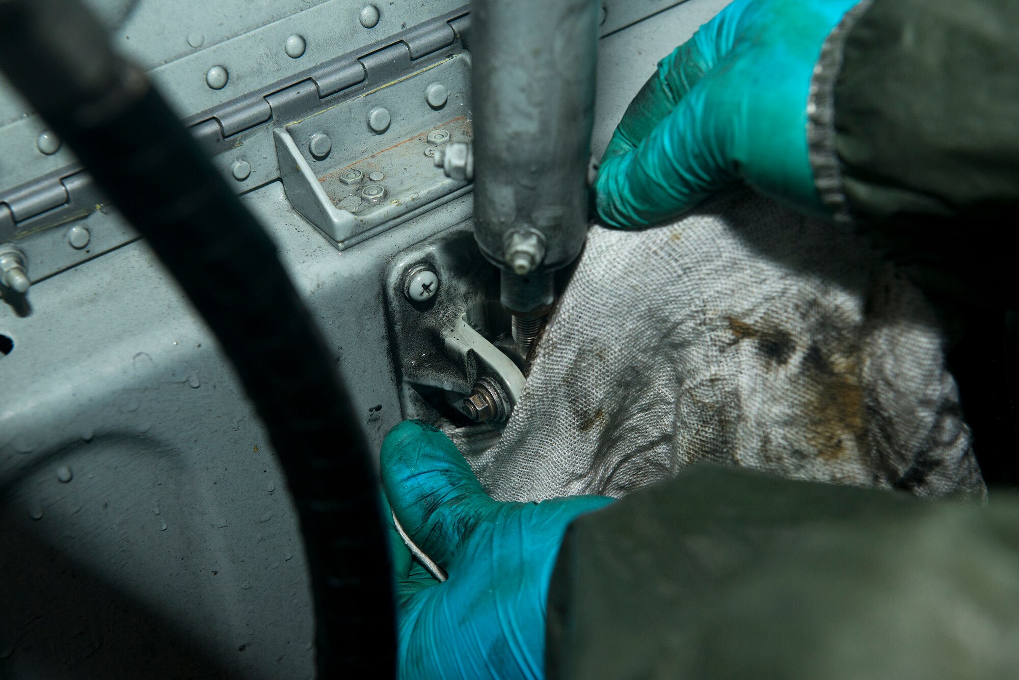 U.S. Air Force Senior Airman Nicholas Bishop, 71st Rescue Squadron aerospace maintenance crew chief, cleans a door-opening mechanism on an HC-130J Combat King II Sept. 1, 2015 at Moody Air Force Base, Ga. Every outside part of the aircraft that can be cleaned with soap and water gets scrubbed by the Airmen in the hangar. (U.S. Air Force photo by Airman 1st Class Kathleen D. Bryant/Released)

