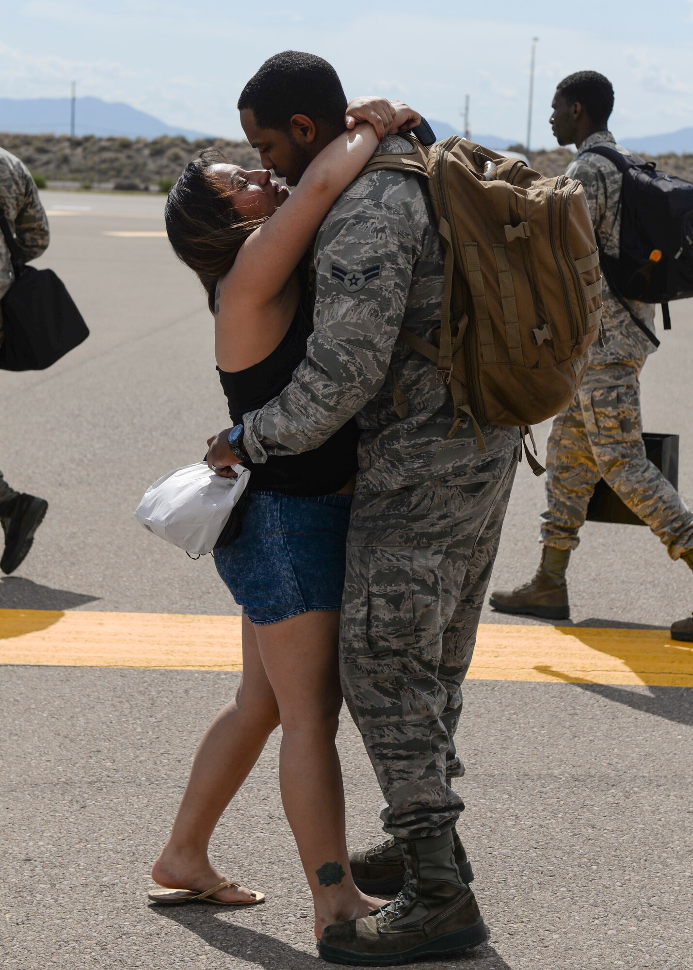 Airman 1st Class Isaiah Watkins of the 311th Fighter Squadron and his girlfriend, Patty Farfan, embrace each other after his return to Holloman Air Force Base, N.M. on Aug 29. Watkins supported the Red Flag exercise conducted at Nellis Air Force Base, Nev. The 311th FS acted as aggressors to help train international coalition fighter pilots during the exercise. (U.S. Air Force photo by Staff Sgt. E’lysia A. Wray)