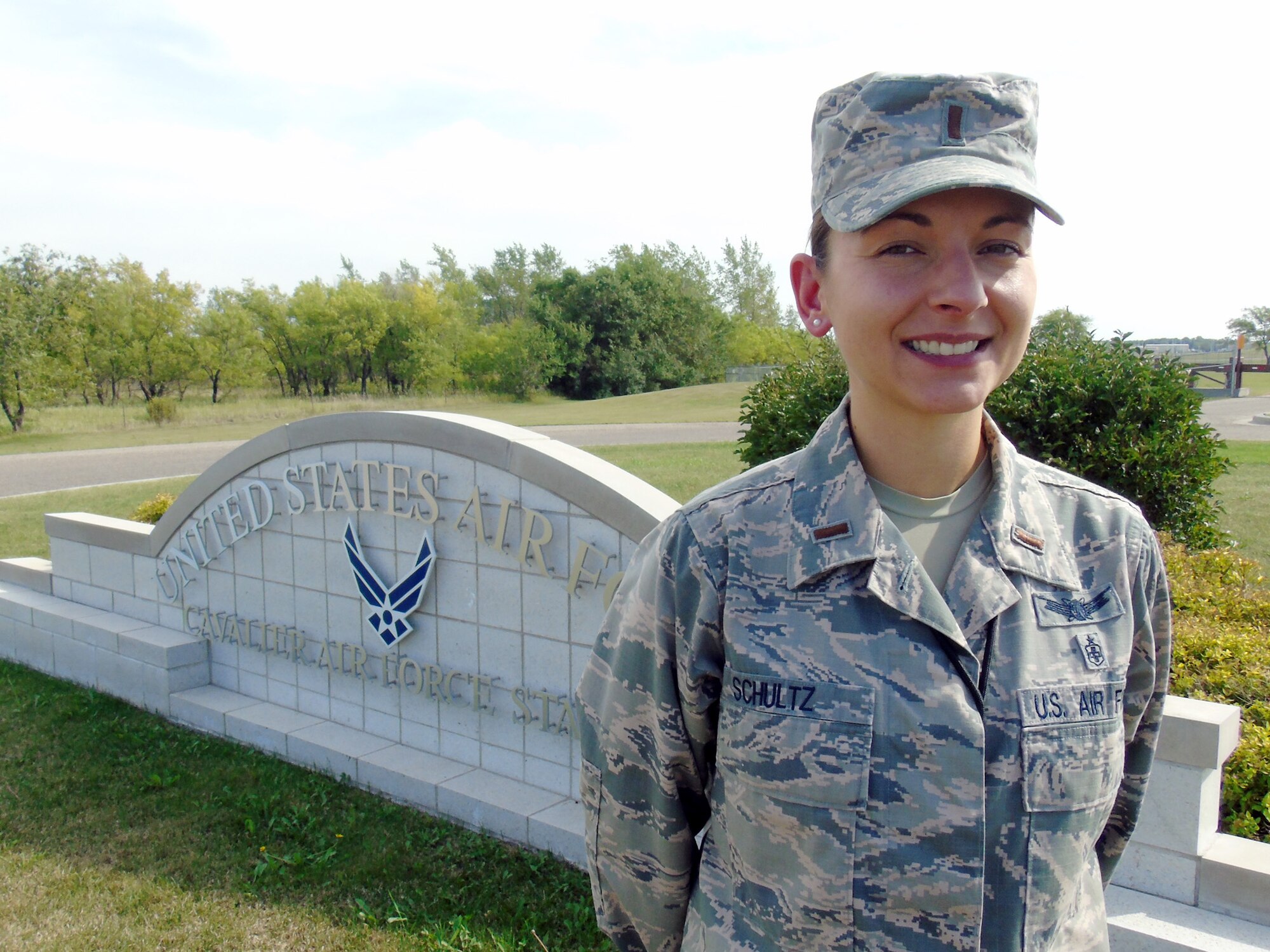 2nd Lt. Emily Schultz, 10th Space Warning Squadron crew commander, poses in front of the base sign at Cavalier Air Force Station, North Dakota, Aug. 31, 2015. Schultz was named the Warrior of the Week for the first week of September 2015. (Courtesy photo by 2nd Lt. Brandy Benesch/Released)