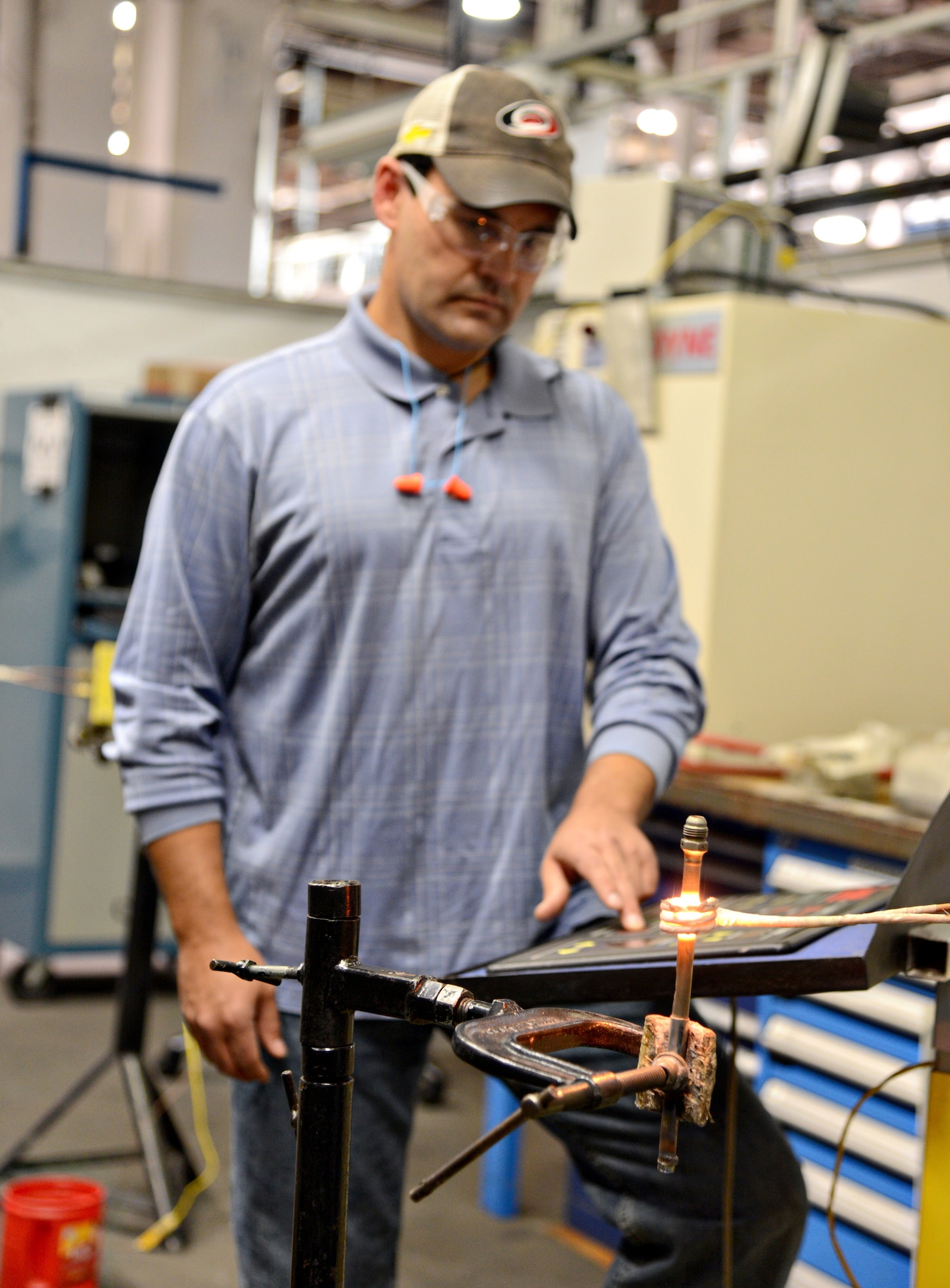 Darren Raines debrazes a supply tube for an F110 engine. The equipment works like an induction heater and can reach temperatures of more than 2,700 degrees to be able to separate pieces of various metals. (Air Force photo by Kelly White/Released)