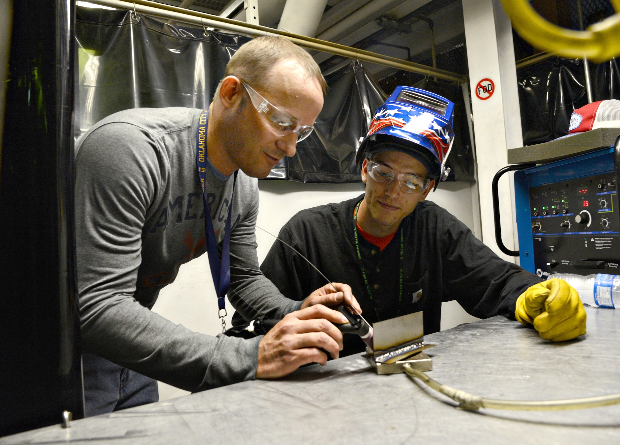 Lester Walker, an observing official for the welding shop, checks the work of Derrick Long, a new hire with the 545th Propulsion Maintenance Group. (Air Force photo by Kelly White/Released)