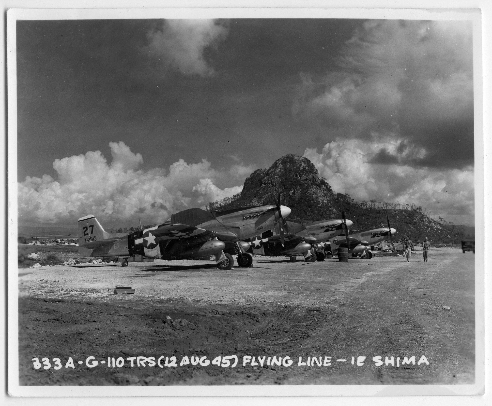 F-6D Photo Mustangs of Les Donis’ 110th Tactical Reconnaissance Squadron rest in the shadow of the volcanic cone on Ie Shima 12 August 1945, a week before the arrival of the white-painted BETTY bombers on the small island.  (US Army via Mr. John Donis)