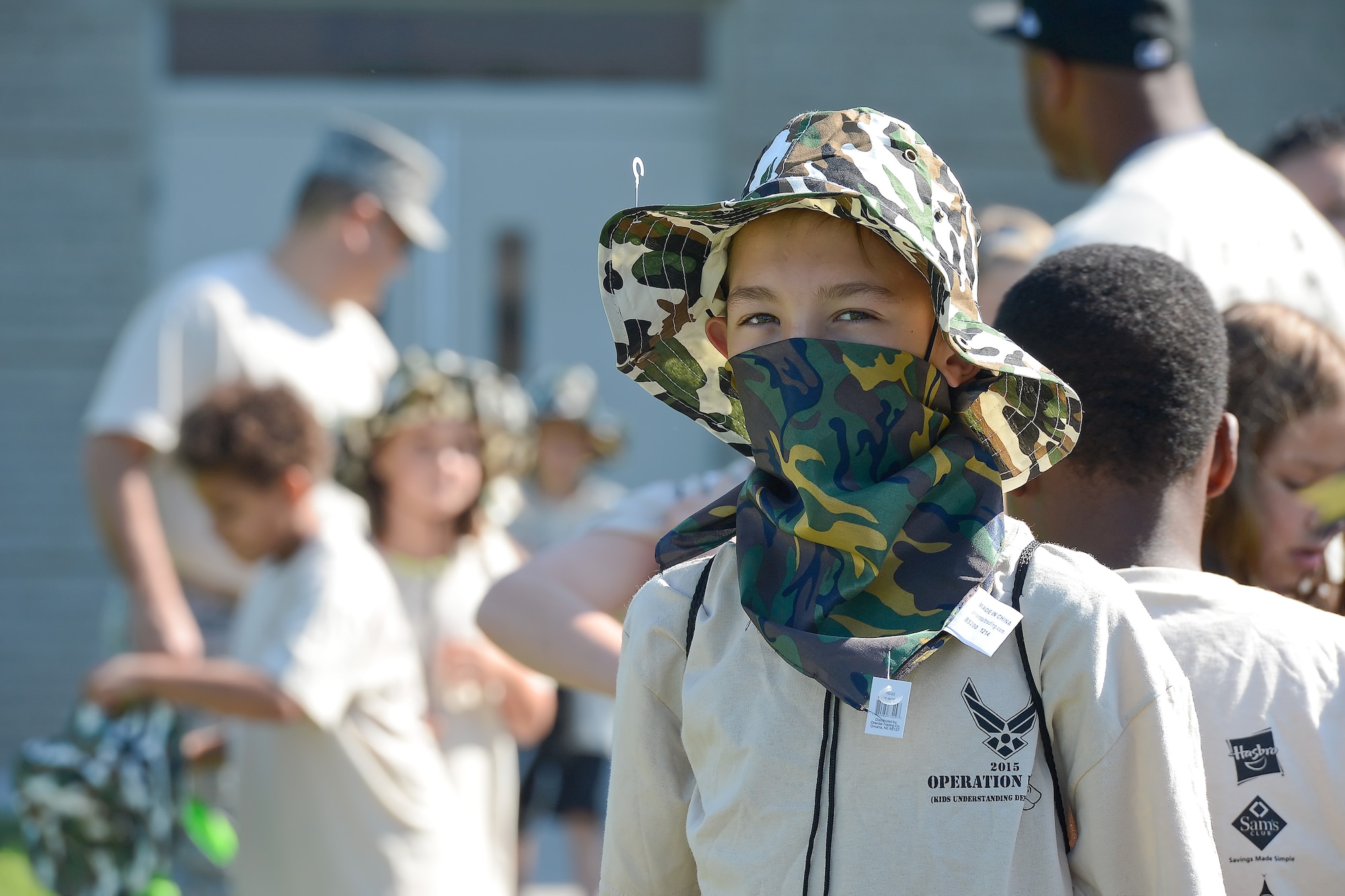 Benjamin Paradis, Welch Elementary School student, peers out from behind a camouflaged hat and bandana during Operation Kids/Teachers Understanding Deployment Operations (KUDOS/TUDOS) Aug. 26, 2015, at the Youth Center on Dover Air Force Base, Del. The hat, bandana and t-shirt were all provided to participants and funded through donations from local businesses. (U.S. Air Force photo/Greg L. Davis)