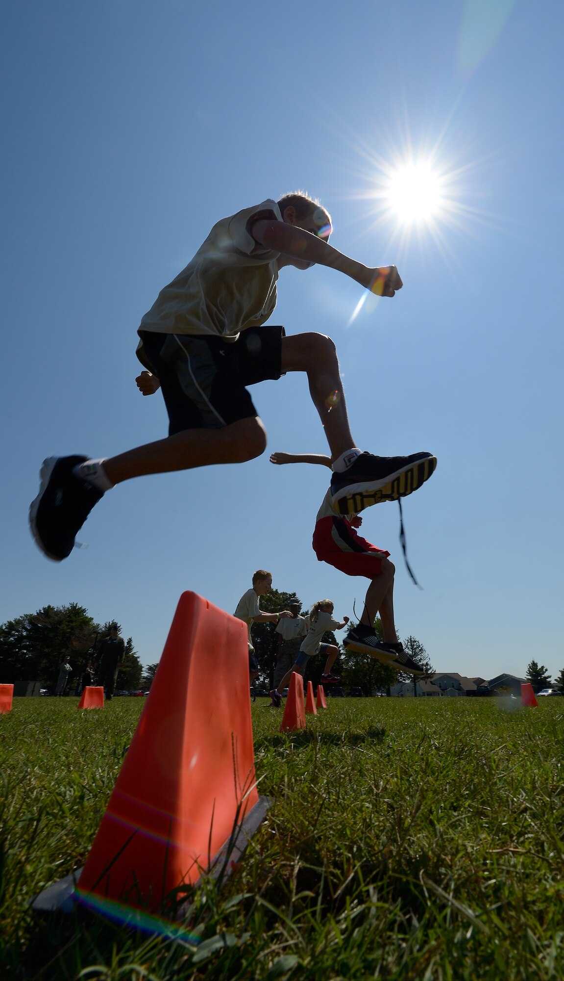 Children run and jump over obstacles while participating in Operation Kids/Teachers Understanding Deployment Operations (KUDOS/TUDOS) Aug. 26, 2015, at the Youth Center on Dover Air Force Base, Del. The fun-filled event allowed the participants to enjoy the beautiful day while experiencing some of the things their parents do when they deploy. (U.S. Air Force photo/Greg L. Davis)
