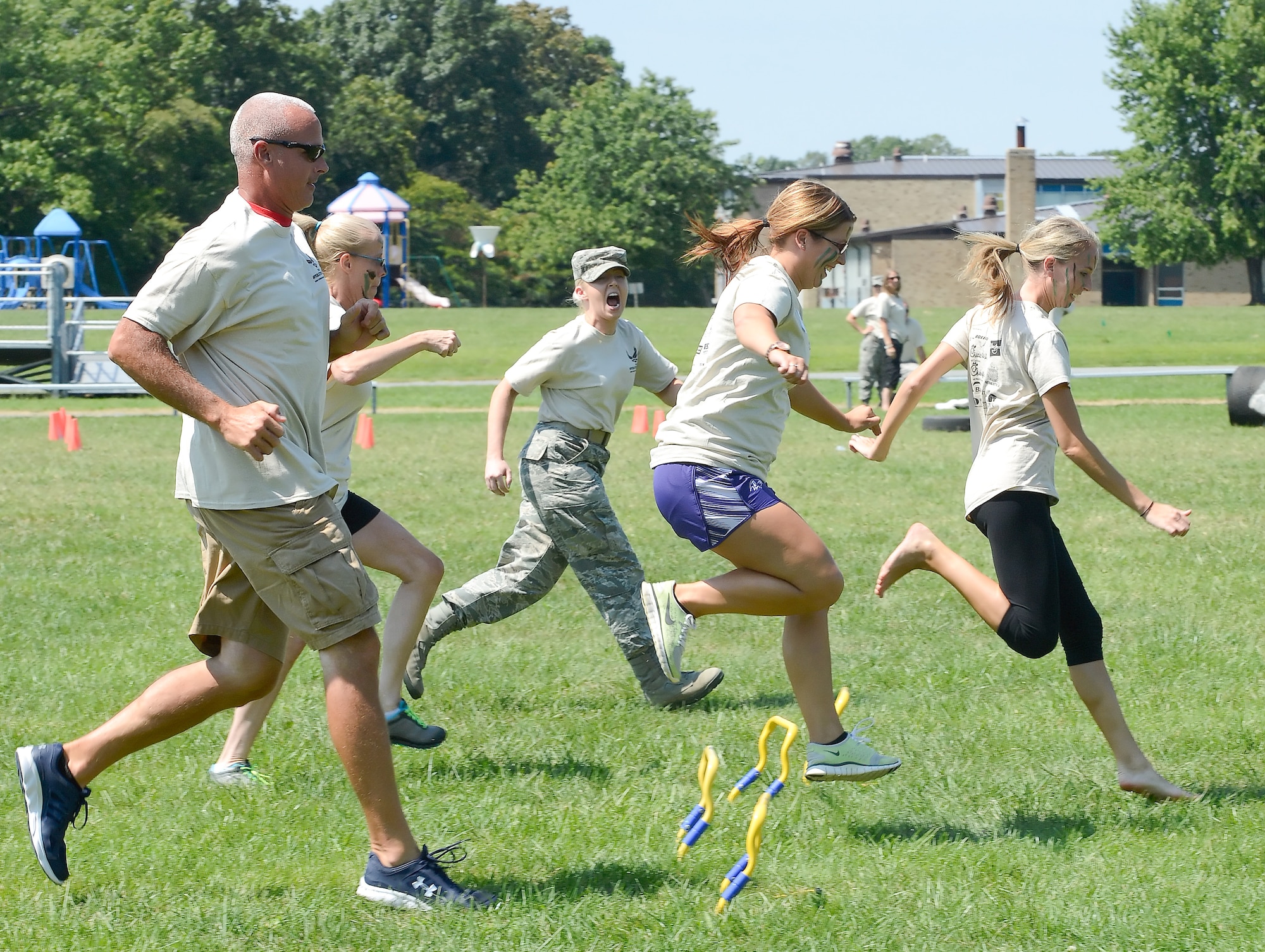 Staff Sgt. Ashton Collins, 436th Dental Squadron, center, yells at teachers as she is hurrying through a short obstacle course during Operation Kids/Teachers Understanding Deployment Operations (KUDOS/TUDOS) Aug. 26, 2015, at the Youth Center on Dover Air Force Base, Del. Collins took on the role of a military training instructor to provide loud and frequent guidance to the participants. (U.S. Air Force photo/Greg L. Davis)