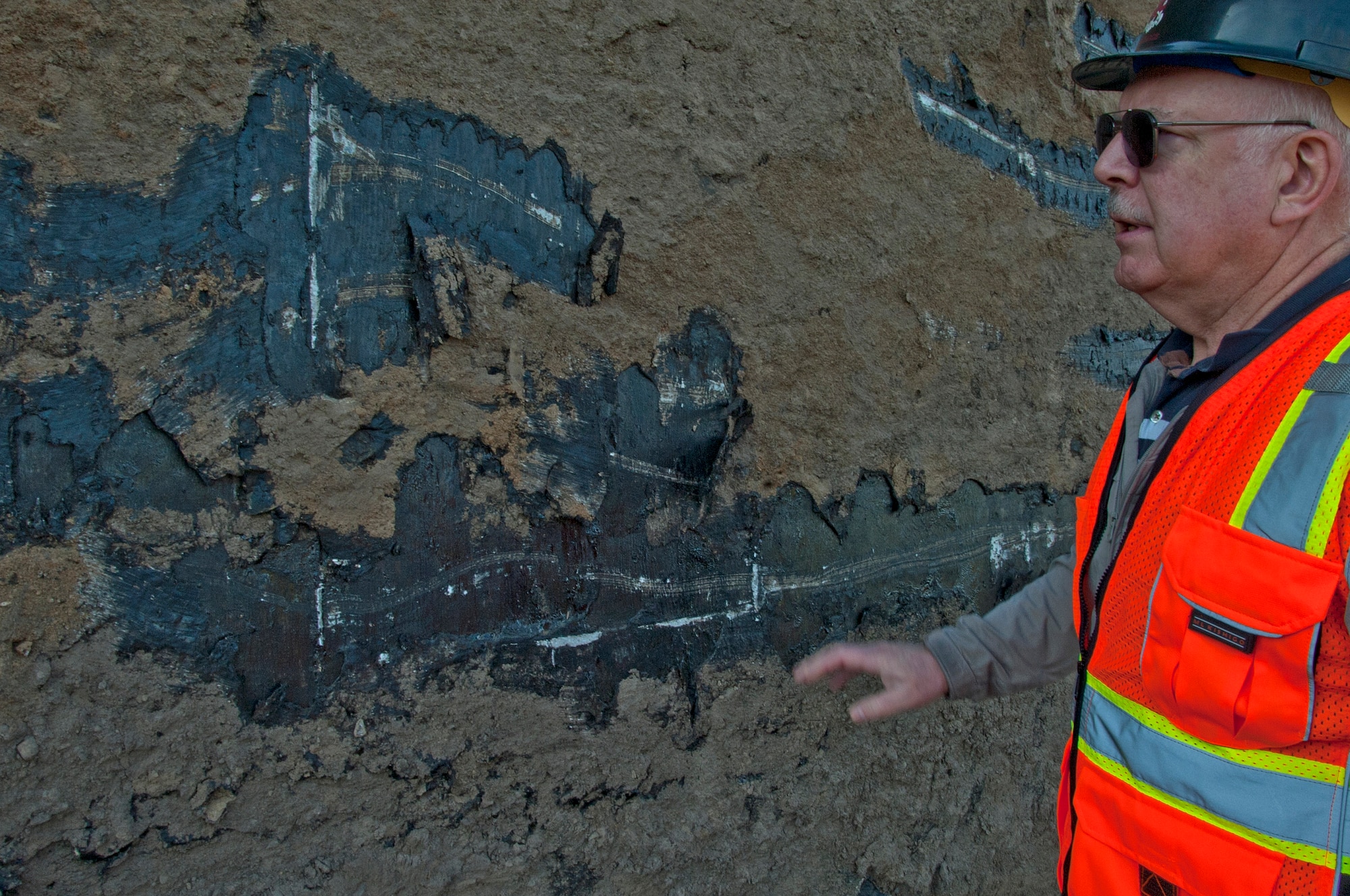 Jay Logan, 92nd Civil Engineer Squadron project manager, talks about the process of originally installing the munitions bunkers in the 1950s Aug. 31, 2015, at Fairchild Air Force Base, Wash. The bunkers were coated in tar until the early 2000s to help reduce plant life growth. (U.S. Air Force photo/Airman 1st Class Mackenzie Richardson)