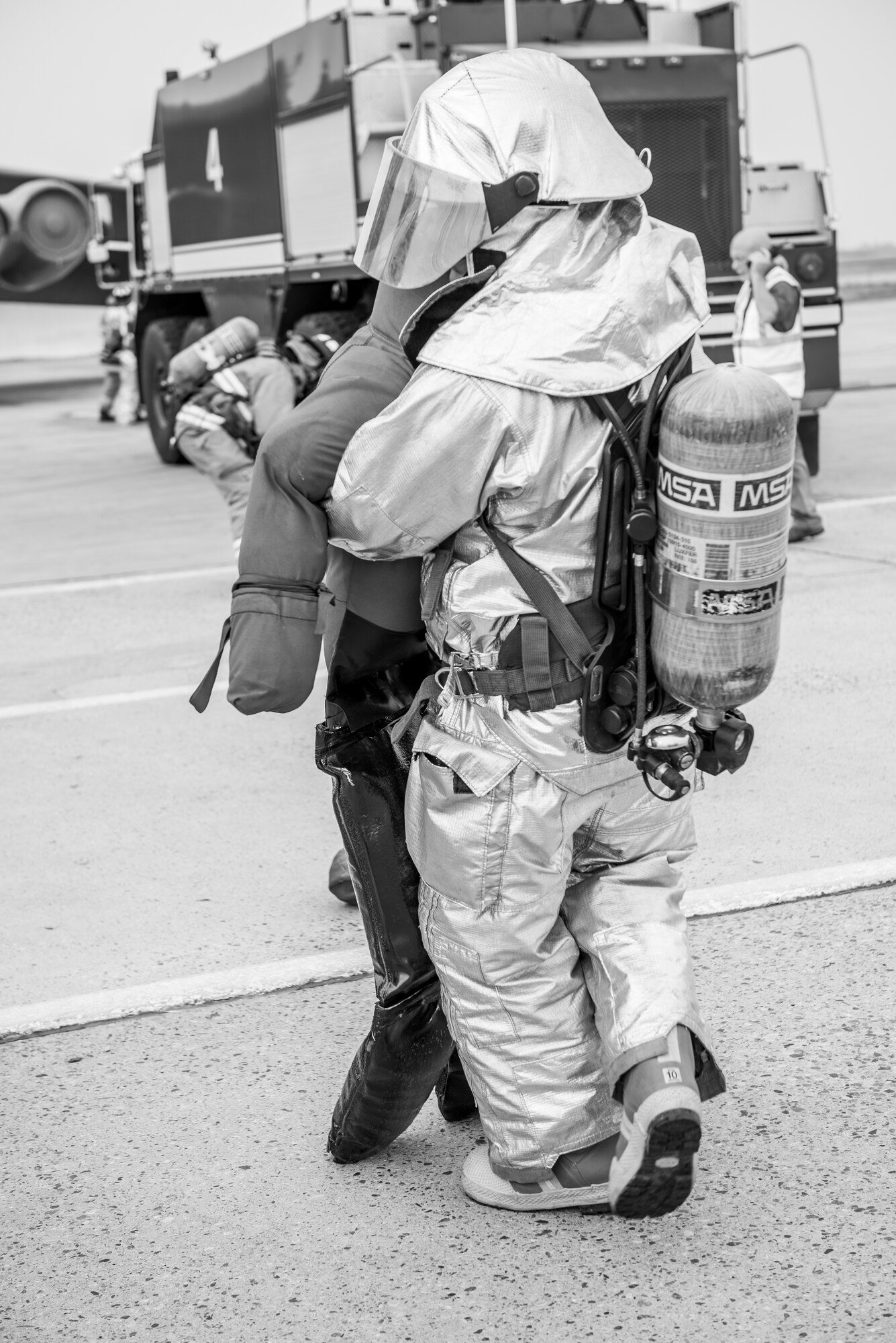 A firefighter from the 5th Civil Engineer Squadron carries a training dummy representing a victim during an exercise at Minot Air Force Base, N.D., August 28, 2015. The purpose of the exercise was to inspect and grade the department’s ability to accomplish the mission safely and work as a team. (U.S. Air Force photo/ Airman 1st Class Justin T. Armstrong)