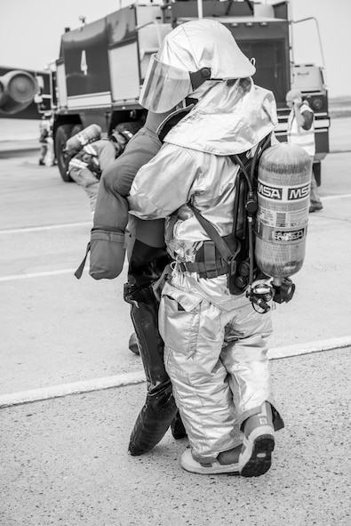 A firefighter from the 5th Civil Engineer Squadron carries a training dummy representing a victim during an exercise at Minot Air Force Base, N.D., August 28, 2015. The purpose of the exercise was to inspect and grade the department’s ability to accomplish the mission safely and work as a team. (U.S. Air Force photo/ Airman 1st Class Justin T. Armstrong)