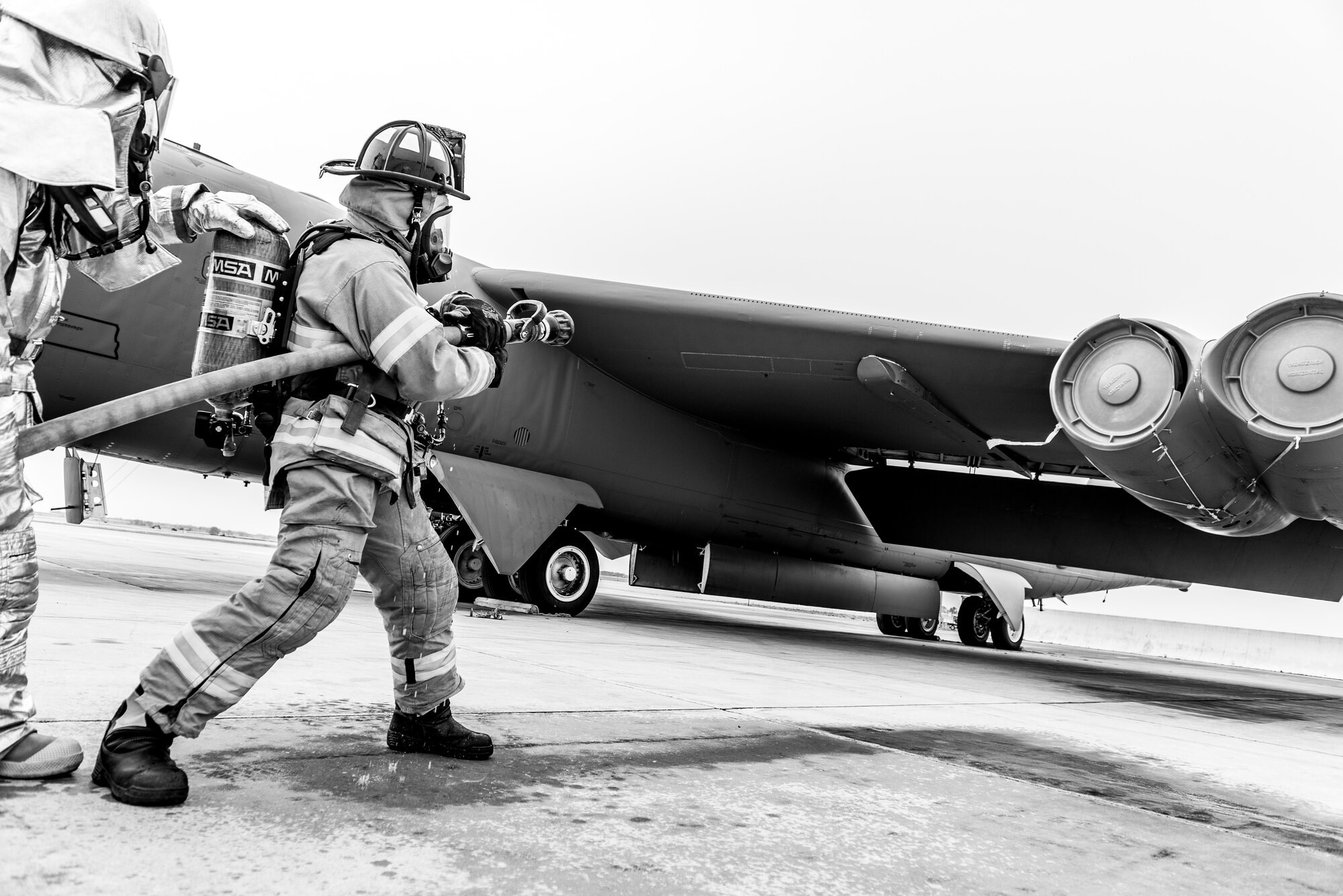 Firefighters from the 5th Civil Engineer Squadron simulate extinguishing an engine fire during a training exercise at Minot Air Force Base, N.D., August 28, 2015.  The exercise lasted about an hour and tested the ability of 15 members of the 5th CES fire department to work as a team. (U.S. Air Force photo/ Airman 1st Class Justin T. Armstrong)