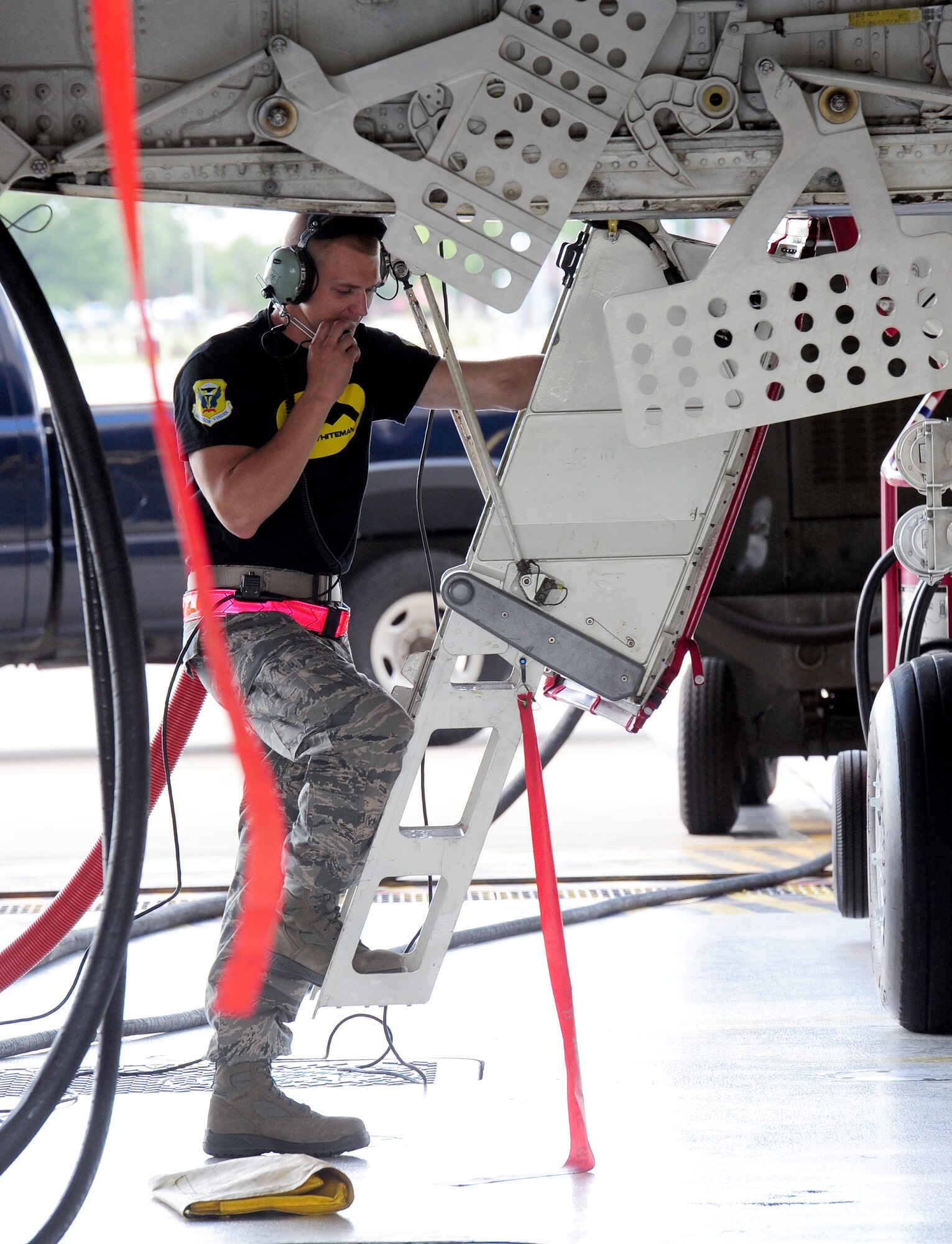 Senior Airman Bobby Hawkins, 131st Aircraft Maintenance Squadron crew chief, communicates with team members to ensure the rotary launcher assembly is in the correct position Aug. 11, 2015, at Whiteman Air Force Base, Mo. Once the weapons are secured, the aircraft is powered on to make sure the munitions in the weapons system are recognized. (U.S. Air Force photo by Airman 1st Class Jazmin Smith/Released)