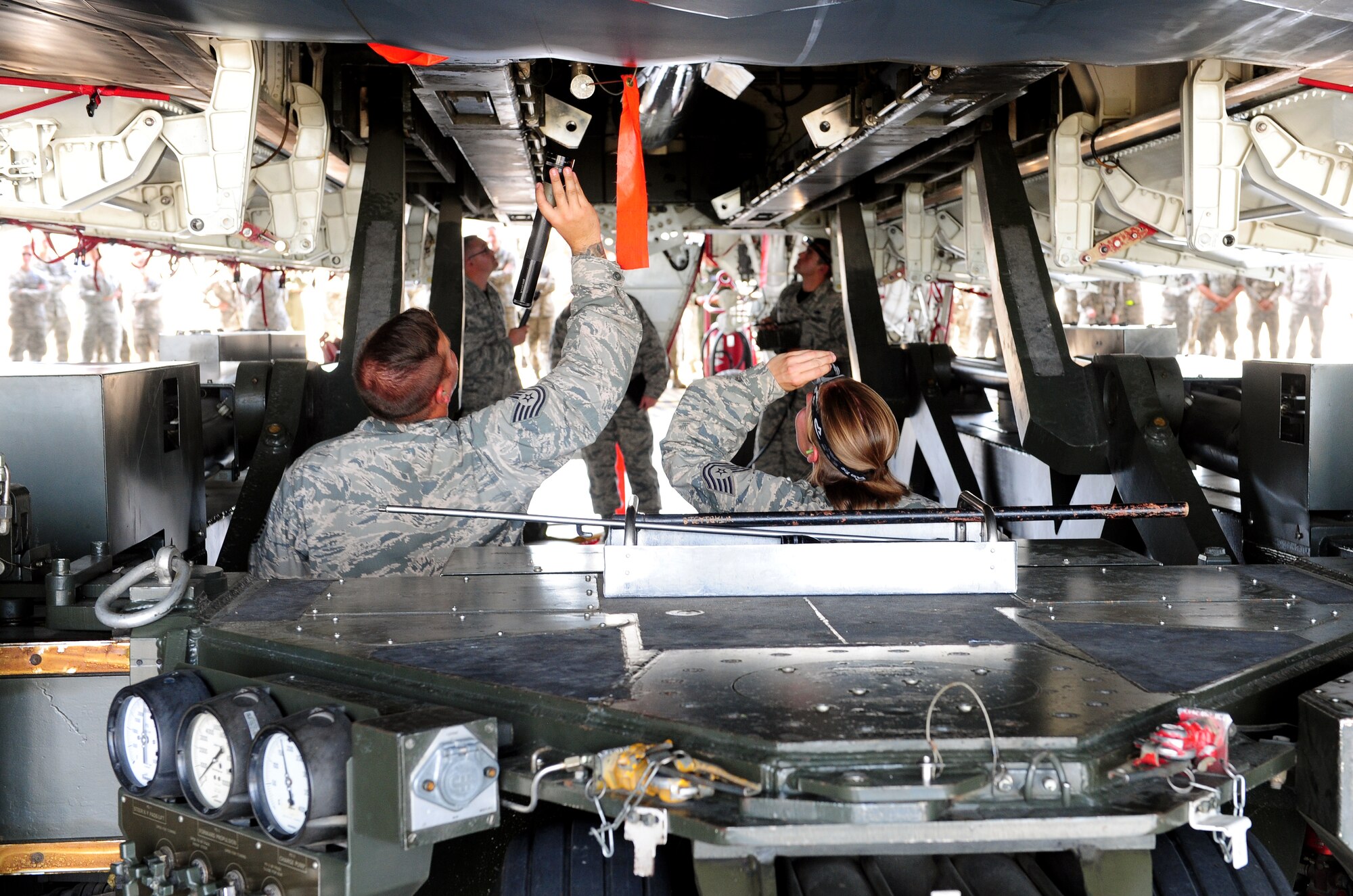 Tech. Sgts. Brock Schuld and Athena Keller, aircraft armament system technicians with the 131st Aircraft Maintenance Squadron, align the rotary launch assembly (RLA) with the weapons bay Aug. 12, 2015, at Whiteman Air Force Base, Mo. The alignment is critical to locking the RLA in place, which is responsible for holding the munitions. (U.S. Air Force photo by Airman 1st Class Jazmin Smith/Released)