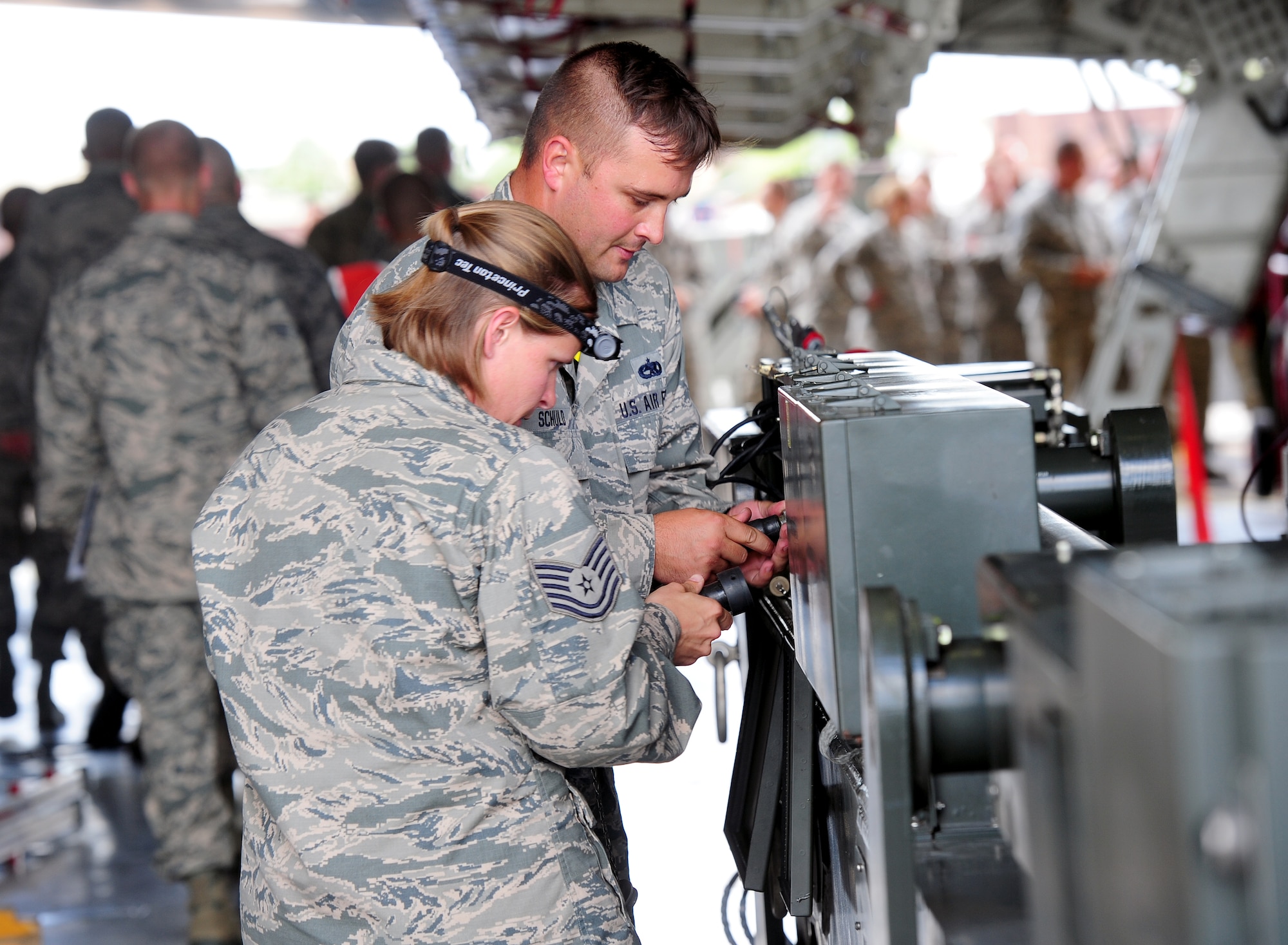 Tech. Sgts. Athena Keller and Brock Schuld, aircraft armament system technicians with the 131st Aircraft Maintenance Squadron, prepare the munitions handling unit (MHU)-204 trailer for operational use Aug. 12, 2015, at Whiteman Air Force Base, Mo. The MHU-204 is an electric and hydraulic- powered trailer that can lift up to 40,000 pounds. During the load, the MHU-204 trailer was used to load the rotary launcher assembly into the aircraft. (U.S. Air Force photo by Airman 1st Class Jazmin Smith/Released)