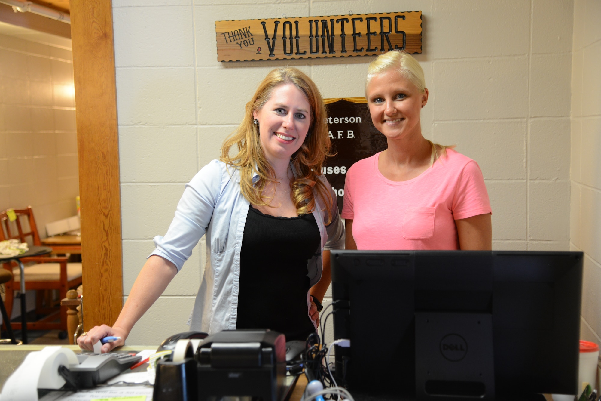 PETERSON AIR FORCE BASE, Colo. – Haila Hill, left, and Tracy Albright, are volunteers at the Peterson Air Force Base Thrift Shop. The Peterson AFB Thrift Shop along with a variety of helping agencies were integral to helping Senior Airman Tyler Symoens, 21st Civil Engineer Squadron firefighter, and his family after a shipping container fired damaged their household goods. (U.S. Air Force photo by Tech. Sgt. Jared Marquis)