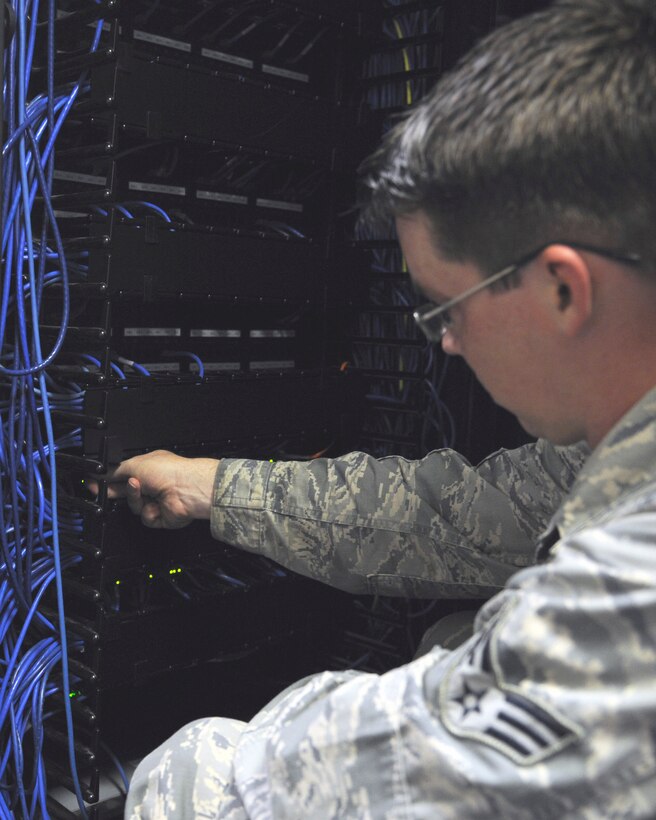 Senior Airman Dylan Connolly, 744th Communication Squadron network management technician, inspects a network switch Sept. 2, 2015, on Joint Base Andrews.  The 14-person shop is responsible for network management of more than 20,000 personnel throughout multiple installations in the National Capitol Region. (U.S. Air Force photo by Senior Airman Preston Webb/Released)