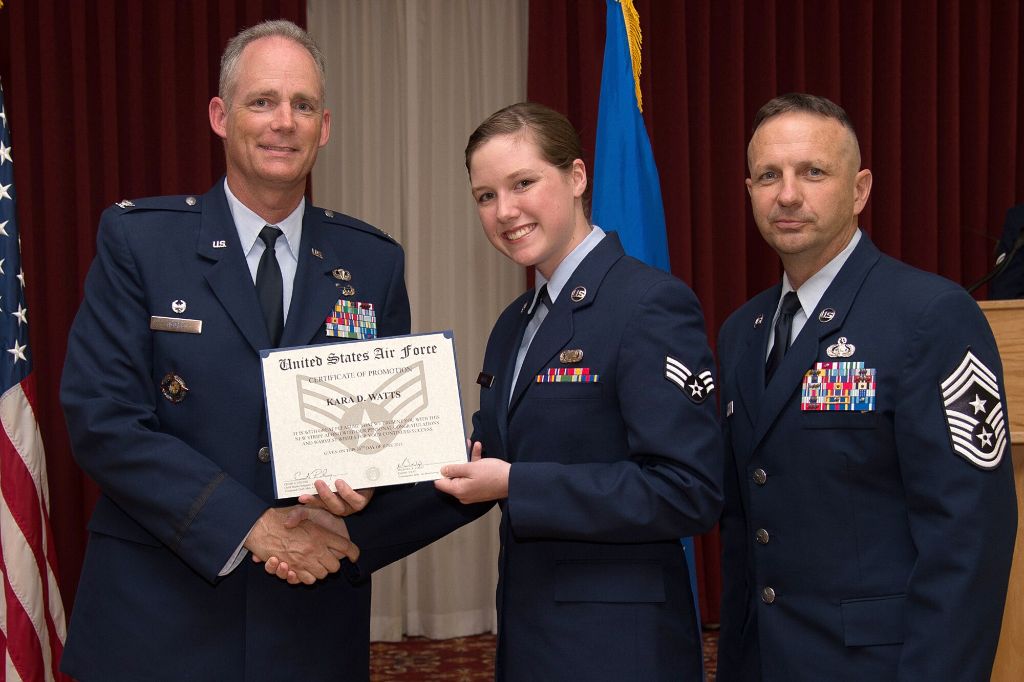 Col. Michael A. Vogel, 66th Air Base Group commander, Senior Airman Kara Watts, 66th Comptroller Squadron administration specialist, and Hanscom Command Chief Master Sgt. Craig A. Poling pose for a photo during the June enlisted promotion ceremony at the Minuteman Commons June 30. Watts was promoted to senior airman after learning she was selected below-the-zone earlier in the month. (U.S. Air Force photo by Mark Herlihy)