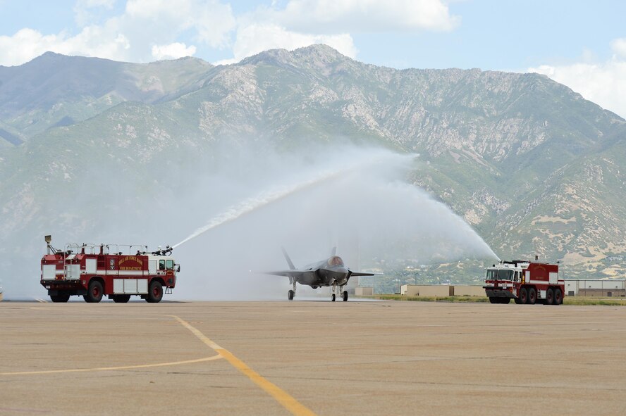 An F-35A Lightning II aircraft passes under a water arch at Hill Air Force Base, Utah, Sept. 2, 2015. The jet and another F-35A, the first of the Air Force’s newest fifth-generation fighter aircraft to arrive at the base, were delivered by Col. David Lyons, 388th Fighter Wing commander, and Lt. Col. Yosef Morris, 34th Fighter Squadron director of operations. The rest of the fleet of up to 72 F-35s will be coming in on a staggered basis through 2019. The 388th and 419th Fighter Wings at Hill were selected as the first Air Force units to fly combat-coded F-35s. (U.S. Air Force photo/R. Nial Bradshaw)