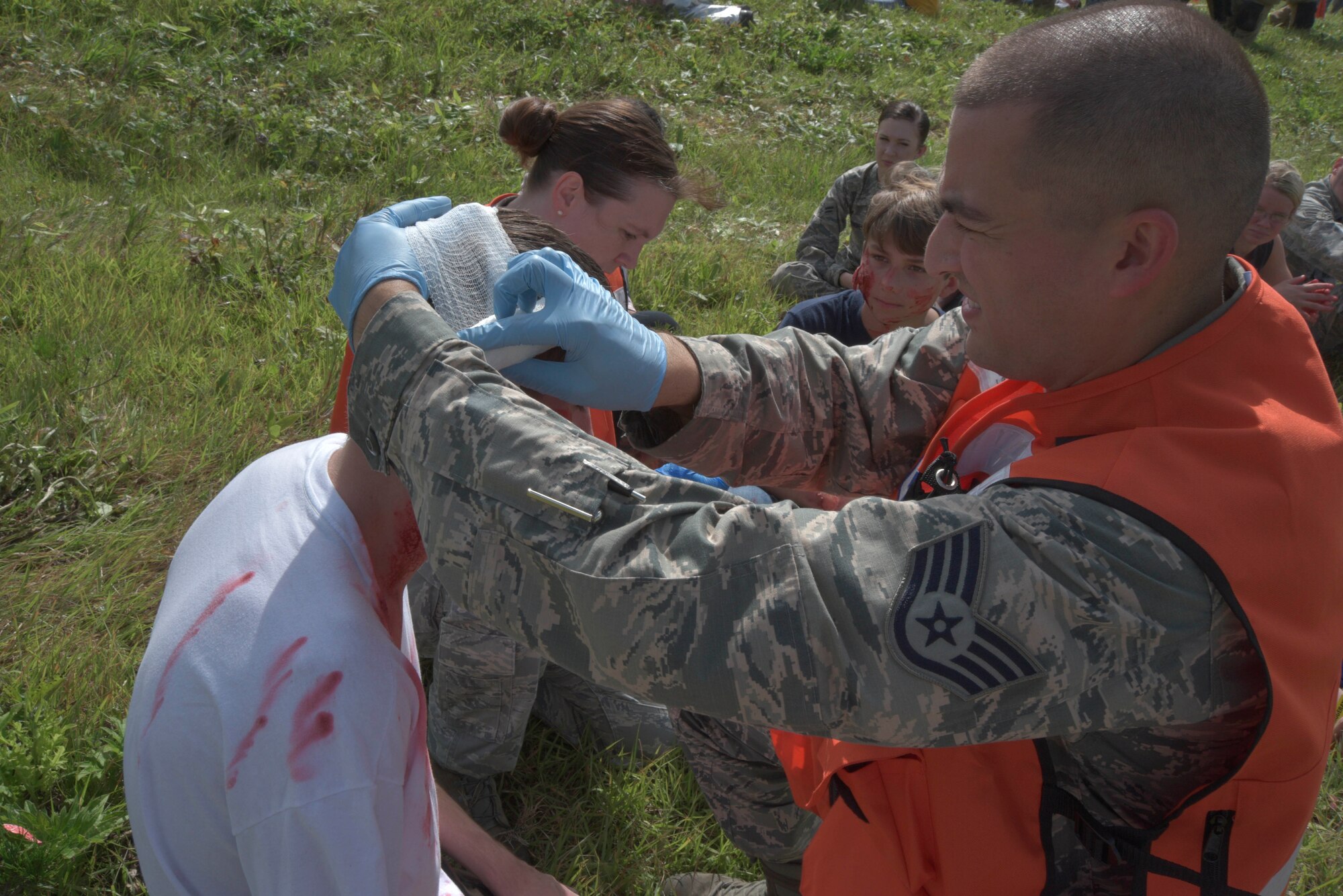 U.S. Air Force Staff Sgt. Andrew, 35th Aerospace Medicine Squadron independent duty medical technician, applies a bandage to a mock injured individual at Misawa Air Base, Japan, Sept. 2, 2015. The “injured” were encouraged to act dramatically to enhance the sense of realism during the exercise. (U.S. Air Force photo by Senior Airman Jose L. Hernandez-Domitilo/Released)