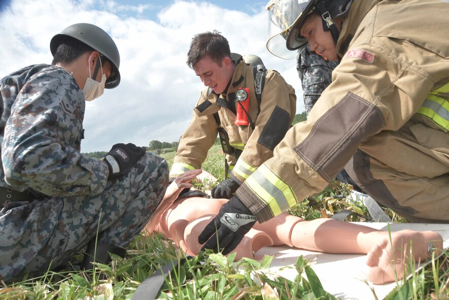 Firefighters from the 35th Civil Engineer Squadron, alongside a Japanese Air Self-Defense Force medical technician, assist a mock injured dummy during an Emergency Management Exercise at Misawa Air Base, Japan, Sept. 2, 2015. The JASDF and U.S. Air Force first responder teams work together for exercises like this annually, demonstrating theater interoperability. (U.S. Air Force photo by Senior Airman Jose L. Hernandez-Domitilo/Released)