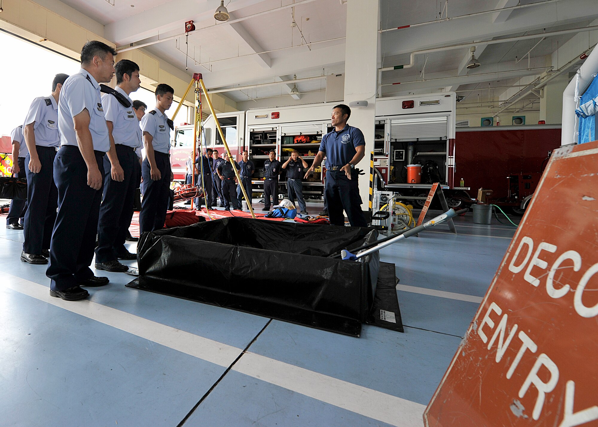 Koichiro Arakaki, 18th Civil Engineer Squadron fire fighter, explains to Japan Air Self-Defense Force students from the 3rd Technical School procedures of the decontamination tent during their tour on Kadena Air Base, Japan, Sept. 2, 2015. During the tour, the JASDF students visited the Fire Department, Explosive Ordnance Disposal Flight, Emergency Management and the 18th Munitions Squadron to learn more about Kadena's explosive solution systems as well as build friendships with their American counterparts. (U.S. Air Force photo by Naoto Anazawa)