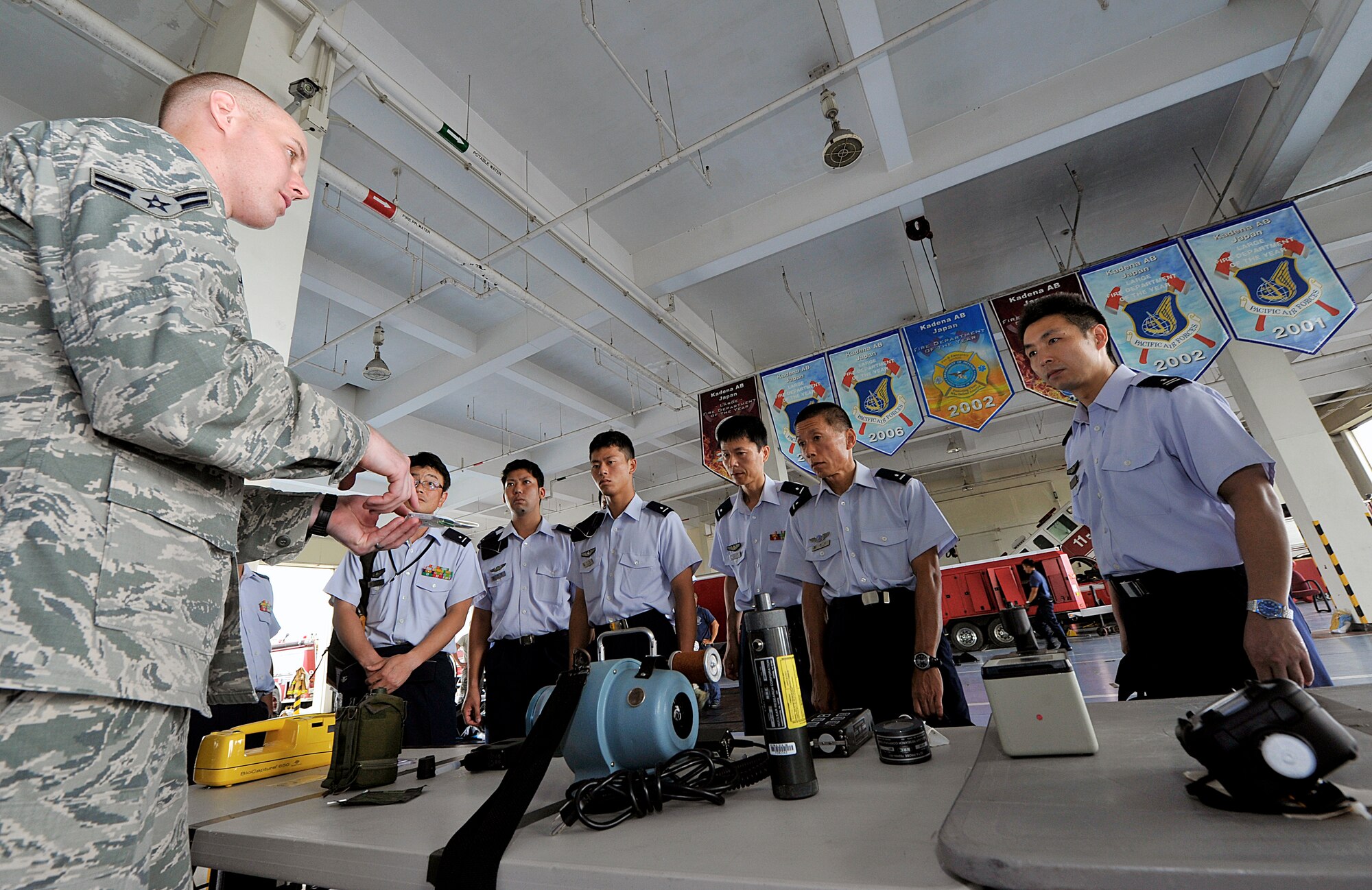 U.S. Air Force Airman 1st Class Joseph Jordan, 18th Civil Engineer Squadron emergency management apprentice, explains to Japan Air Self-Defense Force students from the 3rd Technical School the management of hazards response equipment during their tour at Kadena Air Base, Japan, Sept. 2, 2015. During the tour, nine JASDF students visited Kadena to learn more about Kadena's explosive solution systems. (U.S. Air Force photo by Naoto Anazawa)