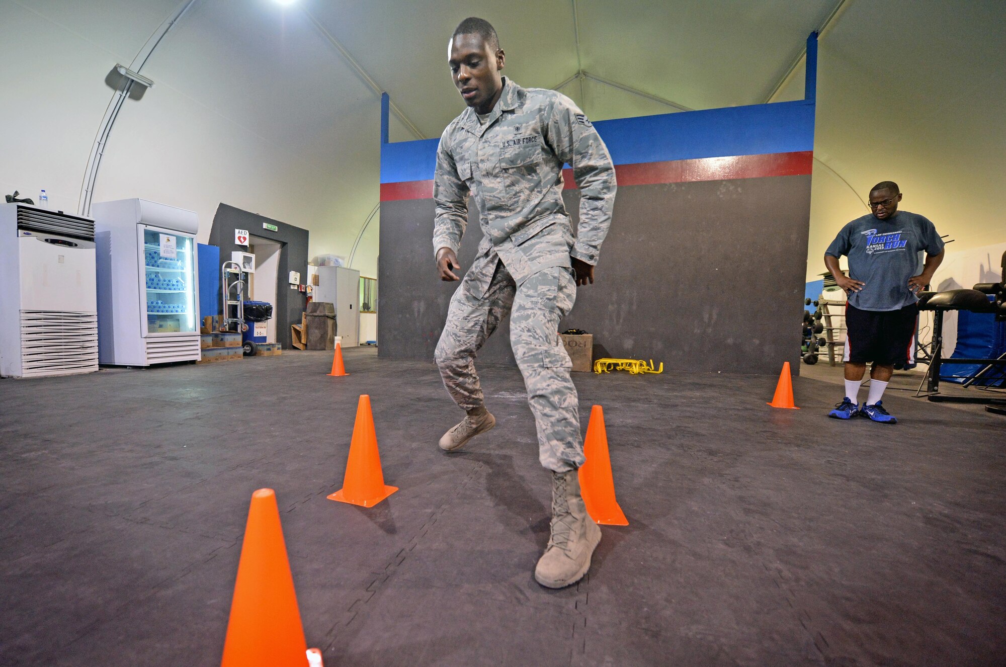 Senior Airman Akil, 380th Expeditionary Medical Group noncommissioned officer in charge physical therapy clinic, left, demonstrates an agility exercise for Staff Sgt. Jamey, 380th Expeditionary Security Forces Squadron member, at undisclosed location in Southwest Asia Sept. 3, 2015. The physical therapy team is responsible for evaluating patients and utilizing different therapeutic procedures to help restore physical abilities. (U.S. Air Force photo/Tech. Sgt. Jeff Andrejcik)  