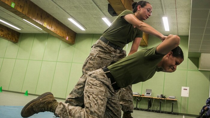 U.S. Marines Lance Cpl. Chevon Ferrel, left, and Cpl. Justine Woodend demonstrate searching techniques during a subject matter expert exchange with the Qatari Internal Security Forces Female VIP Protection Unit in Qatar. Ferrel is an ammunition technician and Woodend is a motor transportation operator with the 15th Marine Expeditionary Unit. They are members of the Female Partner Force Engagement Team. The FPFET was comprised of U.S. Marines with the 15th MEU as well as soldiers and sailors with Special Operations Command Central-Forward and Joint Special Operations Task Force-Arabian Peninsula. During the SMEE they covered medical care, marksmanship, and personal security detail strategies.