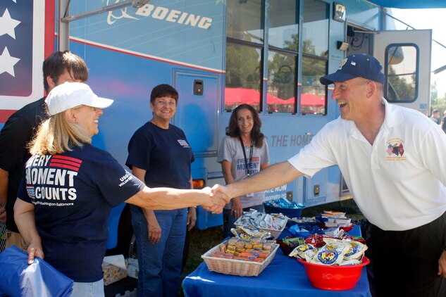Maj. Gen. James W. Lukeman, Training and Education Command commanding general, greets the USO volunteers at the mobile trailer during the TECOM annual Family Day Picnic at Barnett Field, Aug. 27. The USO trailer is a troop support center on wheels, which offers satellite television, sitting area, kitchen and internet access.