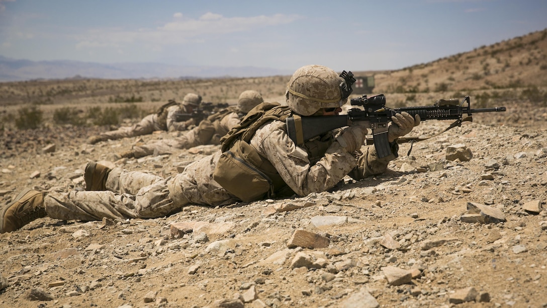 Lance Cpl. Cory B. Larson, rifleman with E Company, 2nd Battalion, 7th Marine Regiment, provides cover fire for his squad during an assault course as part of Exercise Chosin, squad-level training evolution, at Range 410, Marine Corps Air Ground Combat Center Twentynine Palms, California, Aug. 26, 2015. The squad assaulted a trench defense with support from M224A1 60mm Mortars. 