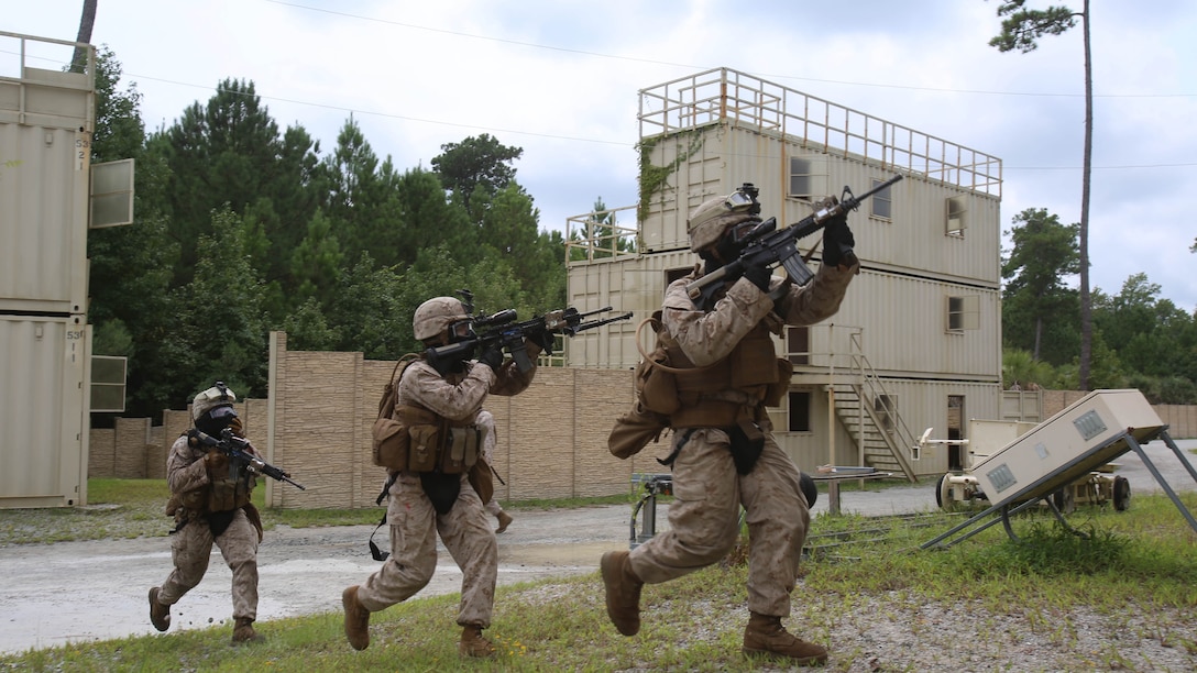 Crossing the danger zone between two buildings, Marines from Fox Company, 2nd Battalion, 2nd Marine Regiment, secure entry to the building they are to clear as part of their military operations in urban terrain training aboard Camp Lejeune, N.C., Aug. 26, 2015. They began with team movements and worked their way up to squad-level sized movements. 