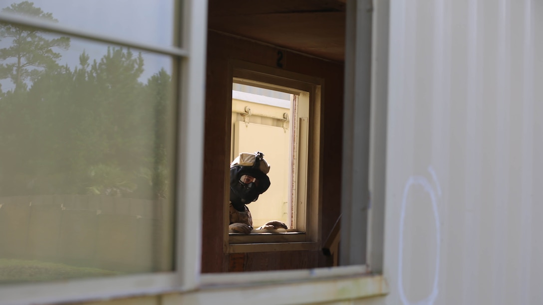 A Marine with  Fox Company, 2nd Battalion, 2nd Marine Regiment, looks in upon the Marines clearing a building during a Military Operations in Urban Terrain exercise aboard Camp Lejeune, N.C., Aug. 26, 2015. Watching and not participating allows the more experienced Marines to point out the junior Marines’ deficiencies and how to correct them. 