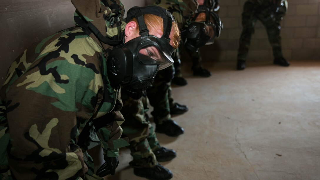 Sgt. Heather Keasler, administrative specialist, Headquarters Battalion, engages in exercises during annual training in the confidence chamber at Range 105, Aug. 27, 2015. CBRN defense specialists burned tablets of Chlorobenzylidene Malononitrile gas to test the Marines confidence with the M50 joint service general purpose mask. 