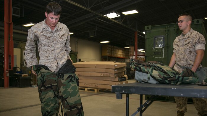 Cpl. Tristofer Ducharme, operator, Unmanned Aerial Vehicle Squadron 1, dons the joint service, lightweight, integrated suit technology during an individual equipment confidence course at building 1980 aboard the Combat Center, Aug. 27, 2015. The JSLIST is designed to protect the wearer from chemical, biological, radiological and nuclear contamination. 