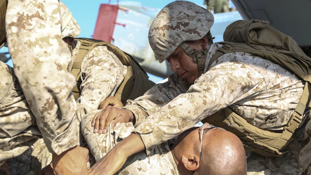 Seaman Jordan Saco, a U.S. Navy Corpsman with Shock Trauma Platoon, Combat Logistics Battalion 13, the logistics combat element for the 13th Marine Expeditionary Unit, helps place a simulated casualty onto a stretcher at Fort Hunter Liggett, California, during training to familiarize medical personnel with attending to casualties arriving on the flight line at Realistic Urban Training (RUT) Exercise, Sept. 2, 2015. RUT is the final ground-based training requirement prior to deployment as the 13th MEU moves toward operating embarked at sea.