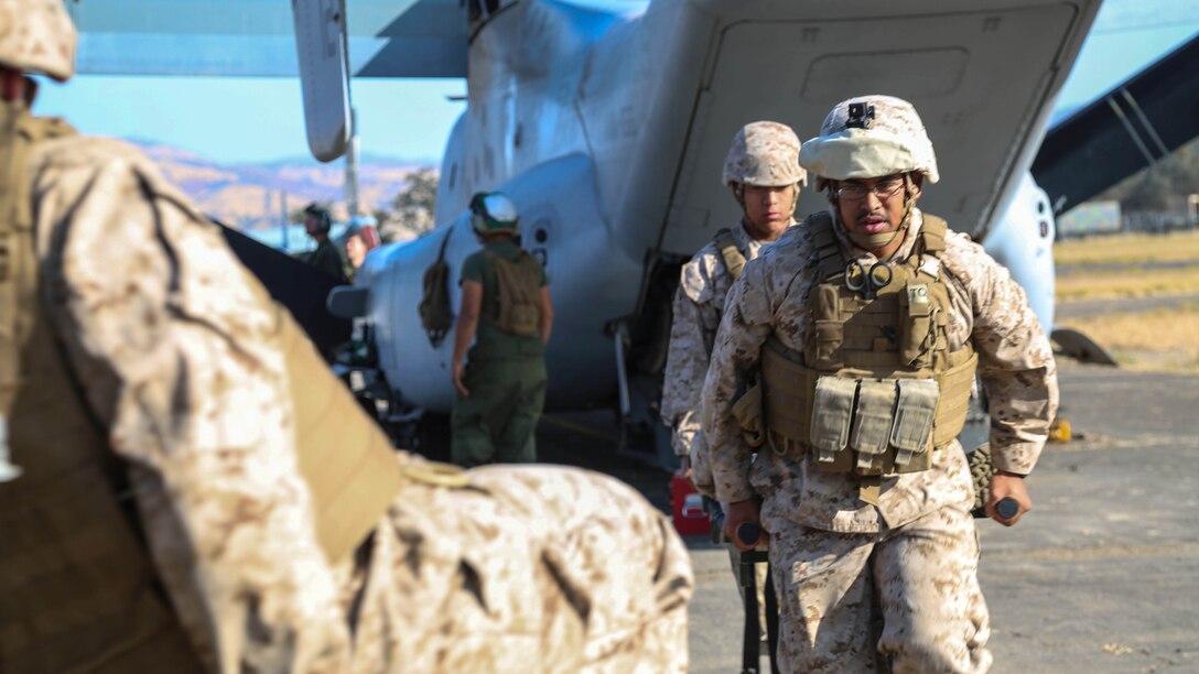 Petty Officer 2nd Class Phillip Lopez (front) and Seaman Jordan Saco, U.S. Navy Corpsmen with Shock Trauma Platoon, Combat Logistics Battalion 13, the logistics combat element for the 13th Marine Expeditionary Unit, carry a simulated casualty on a stretcher to the rear of a medical aid vehicle at Fort Hunter Liggett, California, during training to familiarize medical personnel with attending to casualties arriving on the flight line at Realistic Urban Training (RUT) Exercise, Sept. 2, 2015.  RUT is the final ground-based training requirement prior to deployment as the 13th MEU moves toward operating embarked at sea. 