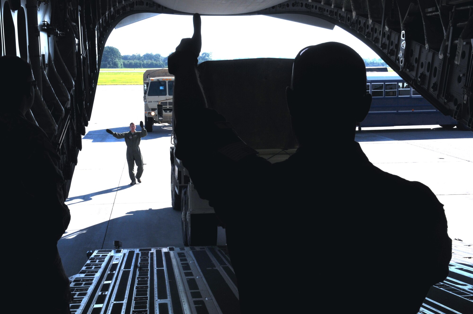 Senior Airman Scott Guerin (left) and Staff Sgt. Doug Wattier of the 317th Airlift Squadron based in Charleston, S.C., use hand signals to direct the loading of a 415th Chemical Brigade Light Medium Tactical Vehicle LMTV into the cargo hold of a Boeing C-17 Globe master on August 15th 2015 in support of Operation Red Dragon. Red Dragon is a Civil Defense readiness exercise, which incorporates Army Reserve and National Guard Soldiers with civilian first responder agencies such as fire departments, police departments and hospitals to improve capabilities in large-scale chemical defense operations. (U.S. Army photo by Sgt. Eben Boothby)