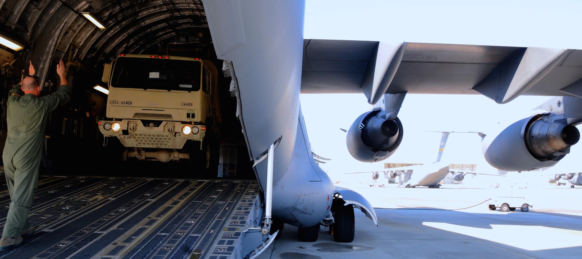 Senior Airman Scott Guerin a Loadmaster with the 317th Airlift Squadron based in Charleston, S.C., directs a Soldier of the 415th Chemical Brigade driving a Light Medium Tactical Vehicle LMTV into the cargo bay of a Boeing C-17 Globe master on Aug. 15, 2015, in support of Operation Red Dragon. Red Dragon is a Civil Defense readiness exercise, which incorporates Army Reserve and National Guard Soldiers. (U.S. Army photo by Sgt. Eben Boothby)