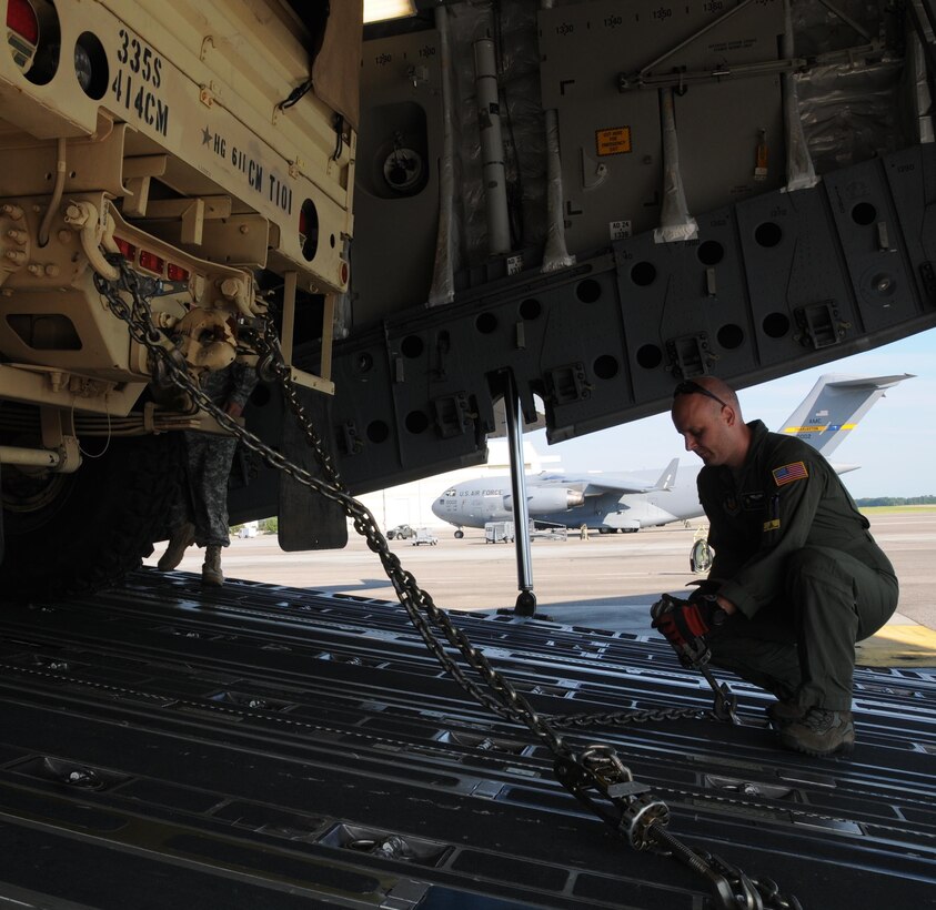 Staff Sgt. Doug Wattier a Loadmaster with the 317th Airlift Squadron based in Charleston, S.C., chains down a Light Medium Tactical Vehicle LMTV into the cargo bay of a Boeing C-17 Globe master Aug. 15, 2015, in support of Operation Red Dragon. Red Dragon is a Civil Defense readiness exercise incorporating Army Reserve and National Guard Soldiers with civilian first responder agencies such as fire departments, police departments and hospitals to improve capabilities in large-scale chemical defense operations. (U.S. Army photo by Sgt. 1st Class Anthony Florence)