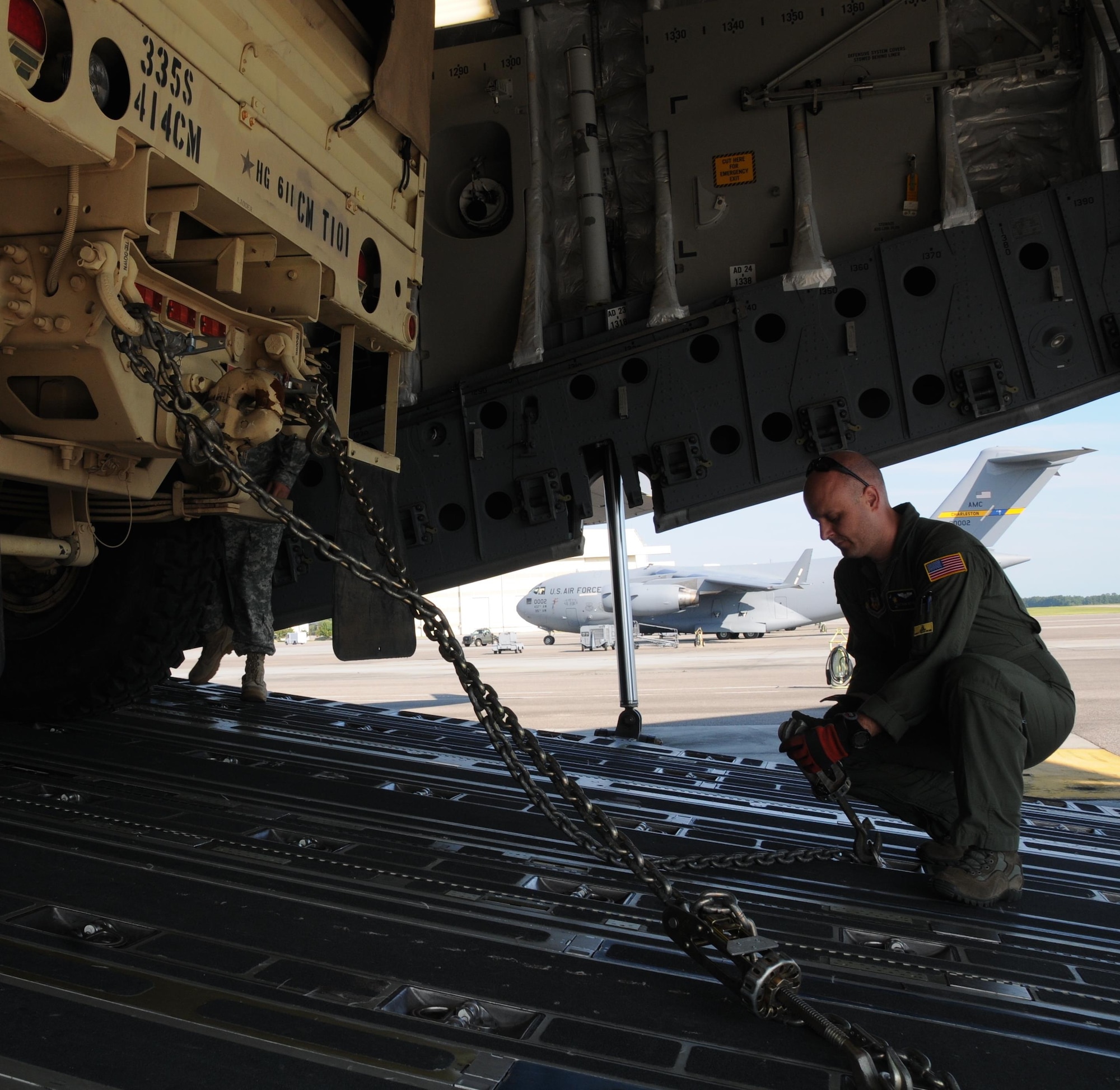 Staff Sgt. Doug Wattier a Loadmaster with the 317th Airlift Squadron based in Charleston, S.C., chains down a Light Medium Tactical Vehicle LMTV into the cargo bay of a Boeing C-17 Globe master Aug. 15, 2015, in support of Operation Red Dragon. Red Dragon is a Civil Defense readiness exercise incorporating Army Reserve and National Guard Soldiers with civilian first responder agencies such as fire departments, police departments and hospitals to improve capabilities in large-scale chemical defense operations. (U.S. Army photo by Sgt. 1st Class Anthony Florence)