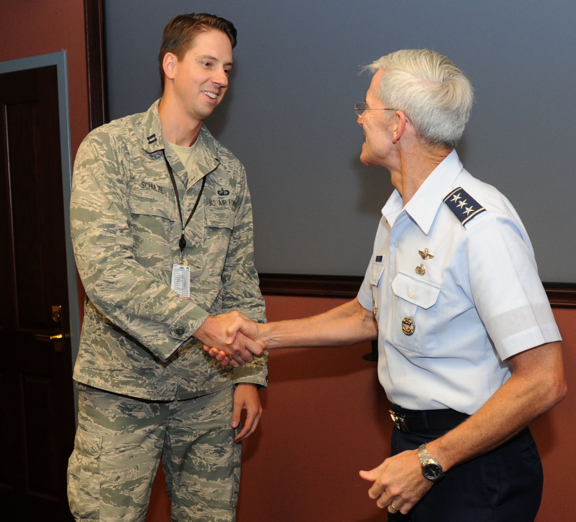 Capt. Benjamin Schulze, a member of the National Air and Space Intelligence Center, receives a coin from Lt. Gen. Robert Otto, deputy chief of staff for Air Force intelligence, surveillance and reconnaissance, following a surprise announcement of Tuesday, Aug. 25, 2015, here. Otto informed Schulze he was named the Air Force’s mid-career outstanding scientist or engineer for 2015. Schulze was able to distinguish himself by bringing next-generation overhead persistent infrared capabilities and tools that are now available to warfighters. The STEM awards recognize the efforts and achievements of top Air Force scientists or engineers who make significant contributions to technology and engineering; or solve technical problems in the development, sustainment, testing, training or advancement of Air Force systems. (U.S. Air Force Photo by Airman 1st Class Samuel Earick)   