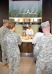 Professional chef Matthew Eisenhour trains Brooke Army Medical Center Dining Facility staff in the art of making pizza in the new pizza oven.