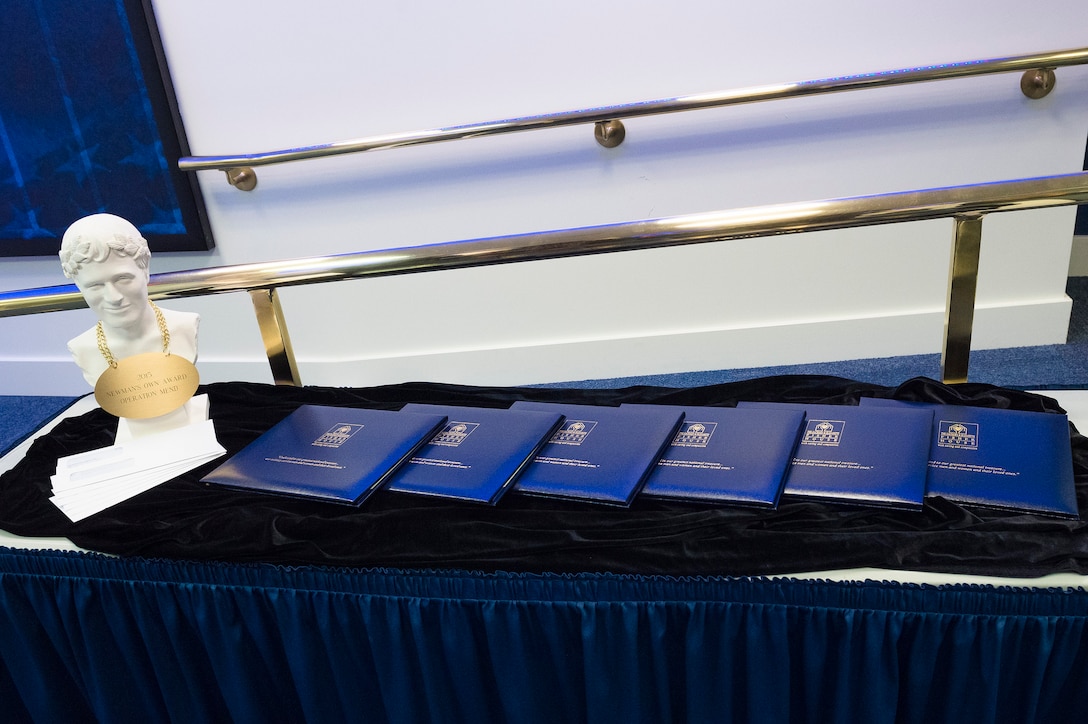 A bust of Paul Newman and folders of awards sit on a table at the annual Newman's Own Awards ceremony in the Hall of Heroes at the Pentagon, Sept. 2, 2015. U.S. Army Staff Sgt. Sean K. Harp/Released