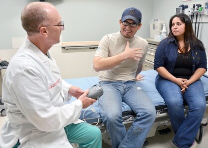 Army Col. (Dr.) Evan Renz, Brooke Army Medical Center commander, explains the function of a vacuum-assisted closure device to Indalecio Morales in the U.S. Army Institute of Surgical Research Burn Center at San Antonio Military Medical Center Aug. 11.