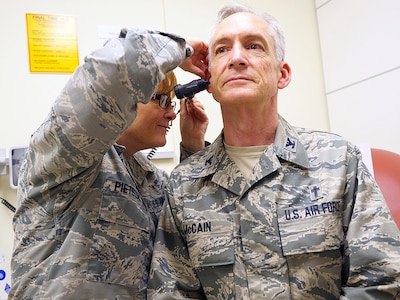 Air Force Col. (Dr.) Kimberly Pietszak, interim chief, Department of Quality Services, and assistant chief, Department of Medicine, examines Air Force Chaplain (Col.) Patrick McCain at the San Antonio Military Medical Center Aug. 26.